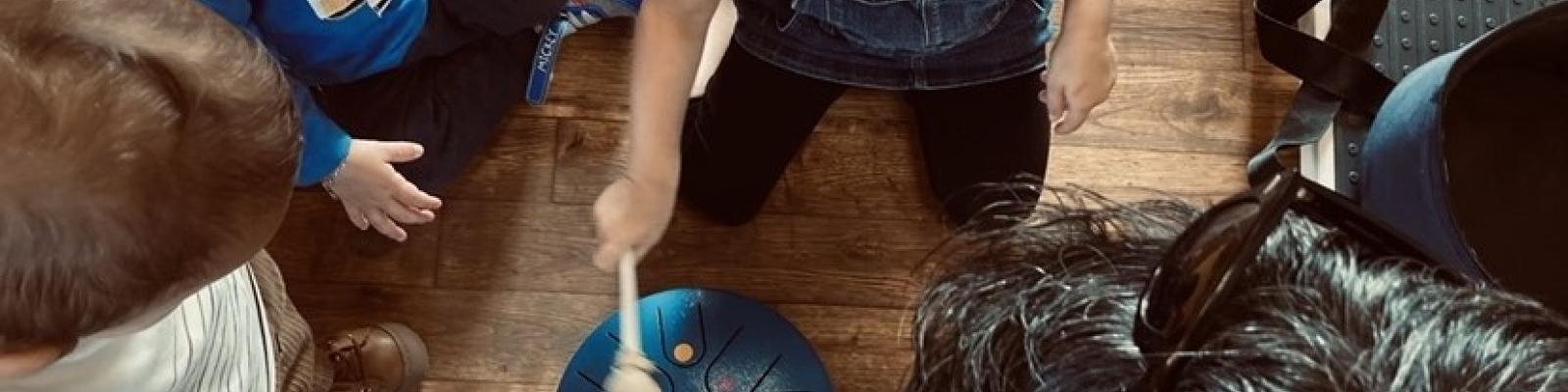 photo de Jonathan et trois enfants en cercle autour d'un instrument de musique